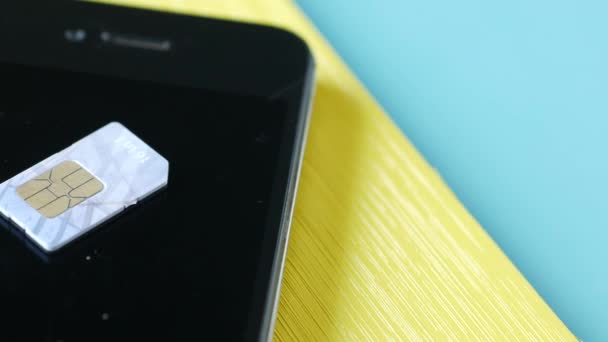 Egy SIM kártya egy okostelefonhoz az asztalon. — Stock videók