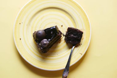 Masadaki tabakta çikolatalı ve kremalı pasta. 