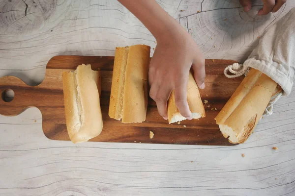 Cutting baked brow bread on table. — Stock Photo, Image