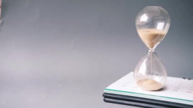 Takvimdeki kum saati ve kum saati ampulünden akıyor.