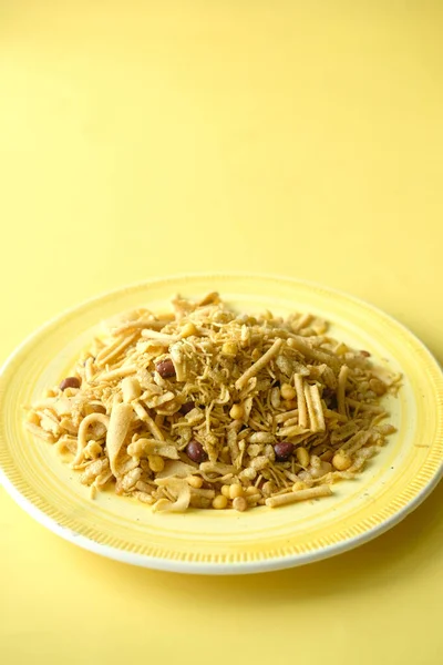 Bombay mix или Chiwda на жёлтом фоне — стоковое фото