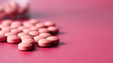 Ağrı kesicinin dökülmesi kırmızı arka planda bir kap oluşturur. 