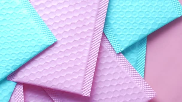 Pink and v blue paper bubble envelope on table — 비디오