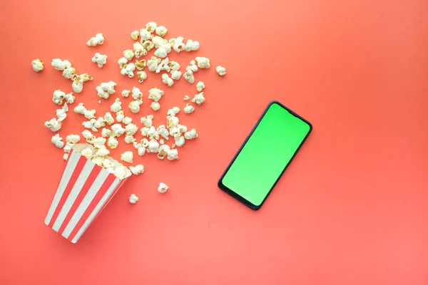Ansicht von Smartphone und Popcorn auf dem Tisch — Stockfoto