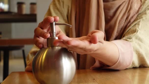 Молодые женщины используют дезинфицирующее средство для рук в кафе — стоковое видео