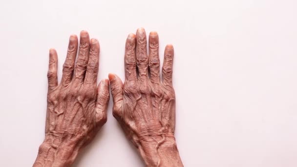 Senior femmes toucher sa main sur fond blanc — Video
