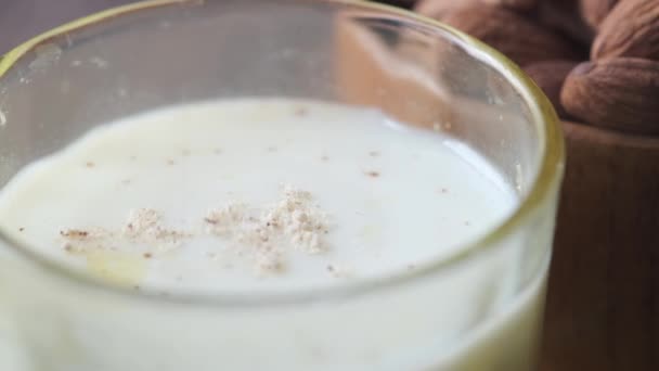 Putting almond powder in a glass of milk — Vídeo de Stock