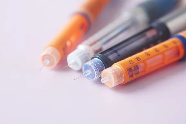 Insulin pens on color background, close up — kuvapankkivalokuva