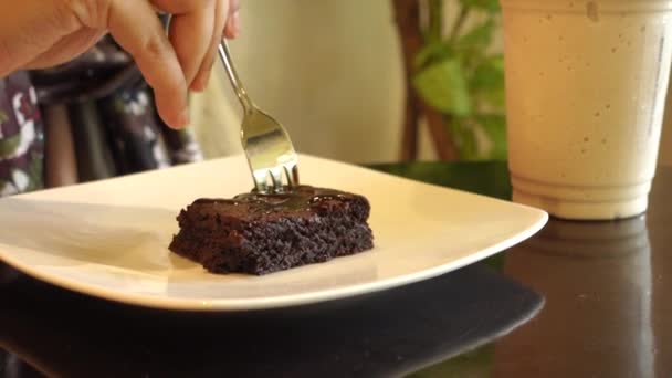 Young women eating brownie on plate on table — Wideo stockowe