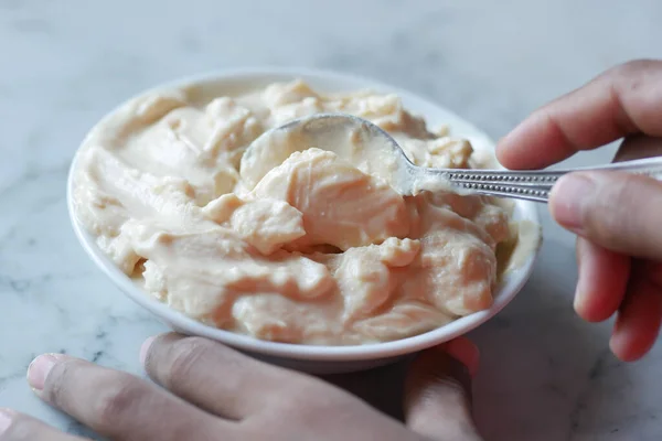 Top view of men hand eating fresh yogurt from a bowl — стоковое фото