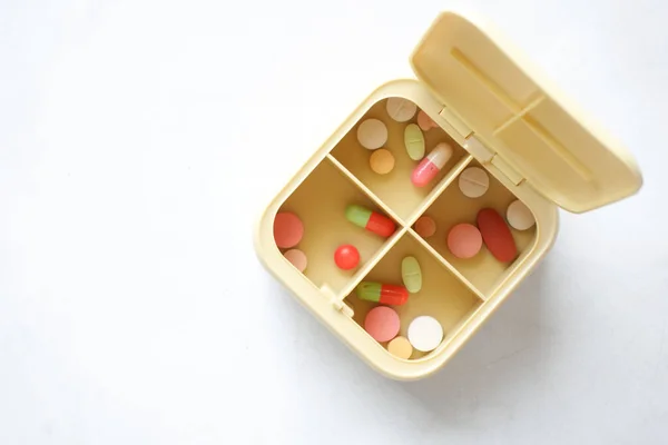 Tıbbi hapları masanın üzerindeki ilaç kutusuna koy. — Stok fotoğraf