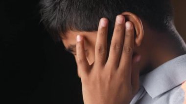  teenage boy having ear pain touching his painful ear ,