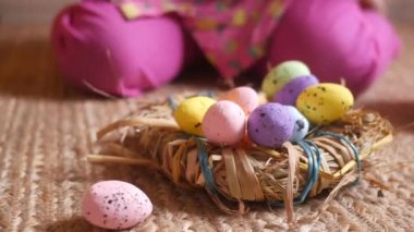 Çocuk eli pembe bir kase paskalya yumurtası tutuyor. 