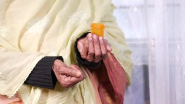 Yaşlı kadınların elindeki hapları ve kapsülleri kapatın.