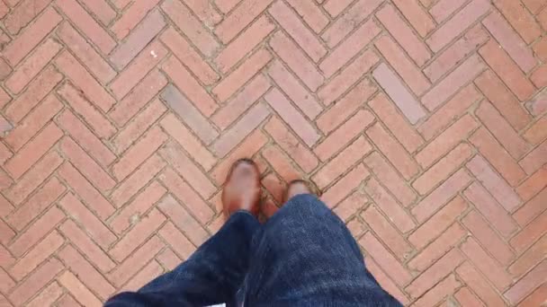 Человек в ботинке ходит по бетонному полу. pov — стоковое видео