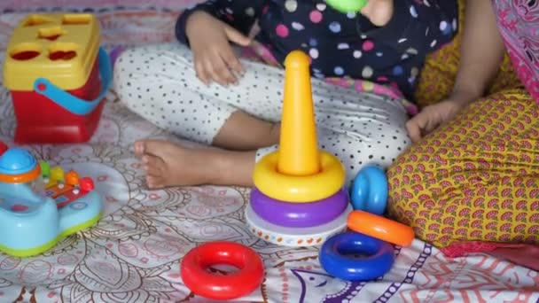Enfant jouant avec un bébé jouets sur le lit, concept de développement de l'enfant. — Video