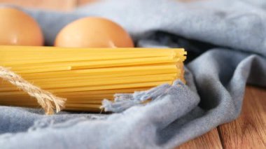 Masada sarı uzun spagetti yumurtası ve yağ var. 