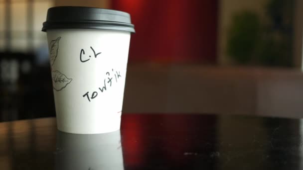 Take away paper coffee cup o on cafe table — Video