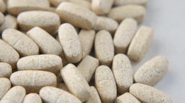  Pembe üzerine beyaz renkli tıbbi haplar dökülüyor. 