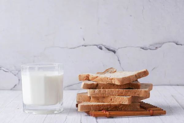 Glass of milk and white bread on table — ストック写真