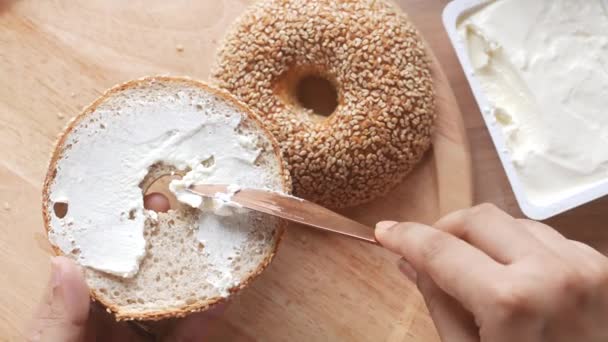 Crema di formaggio spalmata sul pane fresco bagel — Video Stock