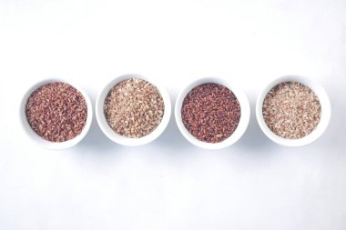 Beyaz arka planda dört farklı pirinç. 