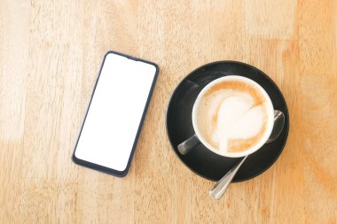  Kalp şeklinde dizaynı ve masada akıllı telefonu olan son model bir kahve. 