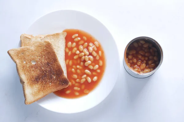 Chutné pečené fazole a chleba na talíři na bílém pozadí — Stock fotografie