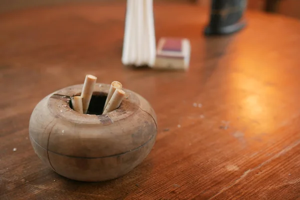 Закрыть сжигание сигарет в пепельнице на столе — стоковое фото
