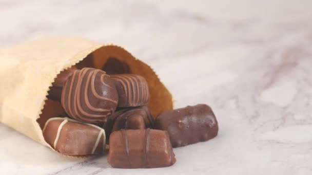 Étcsokoládé kiömlött egy papírcsomagból az asztalon — Stock videók