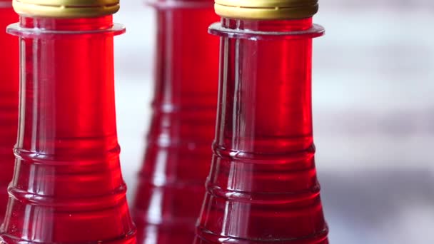 Пластикові пляшки напою червоного кольору на столі — стокове відео