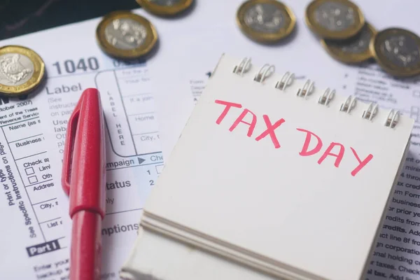 Formularz deklaracji podatkowej i ręczny tekst pisemnego dnia podatkowego w kalendarzu na stole — Zdjęcie stockowe