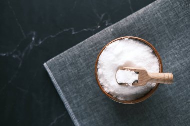 Siyah arka planda bir kasede kaba tuz. 