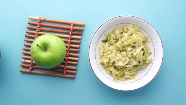 Ansicht von grünem Apfel, Salat und Mandelnuss auf blauem Grund — Stockvideo