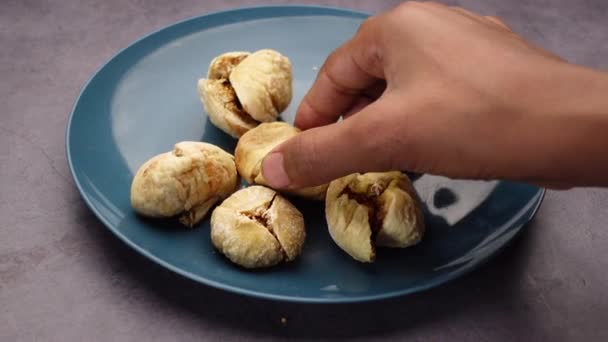 Χέρι πάρει αποξηραμένα φρούτα σύκο σε ένα πιάτο στο τραπέζι — Αρχείο Βίντεο