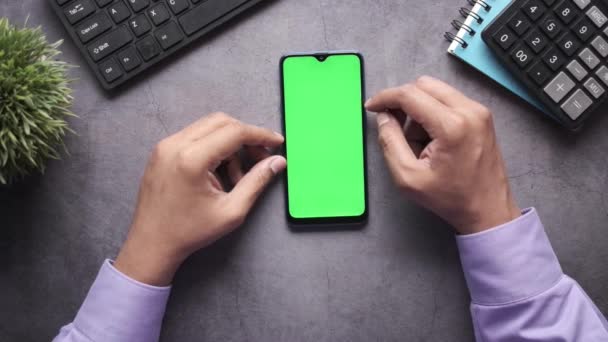 Вид сверху на человеческую руку с помощью смартфона на рабочем столе — стоковое видео