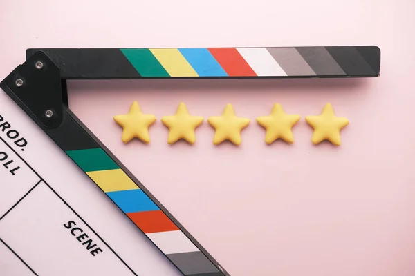 Bewertung goldene Sterne und Filmklappbrett auf farbigem Hintergrund — Stockfoto