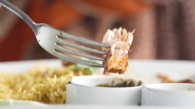 Kızarmış tavuğu soslu dilimlemek ve yemek için çatal kullanıyordu. 