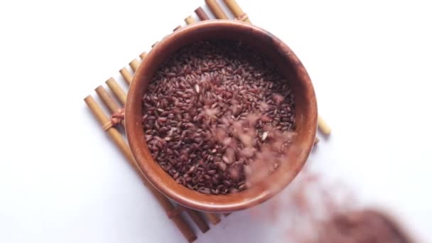 Slow motion av hälla rött ris i en skål på bordet, haradighi ris — Stockvideo