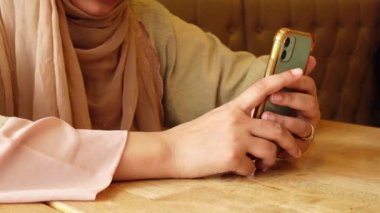  Kafede akıllı telefonları tutan genç kadınlar. 