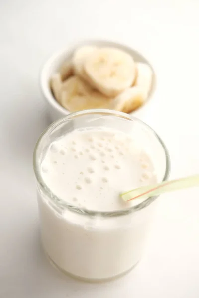 Skiva banan och glas mjölk på bordet — Stockfoto
