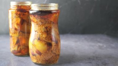 Masadaki cam kavanozda ev yapımı mango turşusu.