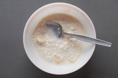 Yulaf, muz ve süt siyah arka planda bir kasede .