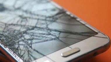 Renk arkaplanındaki bozuk akıllı telefonun üst görünümü.