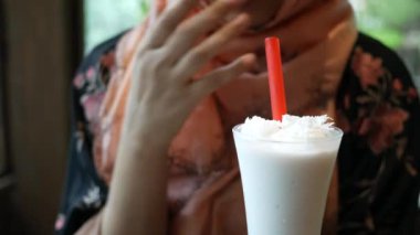 Kafede muzlu milkshake içen genç kadınlar .