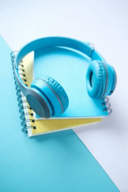 Ses kitabı konsepti. Masada kulaklık ve not defteri var. .