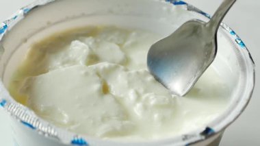 Yavaş çekimde taze yoğurt ve kaşık. .