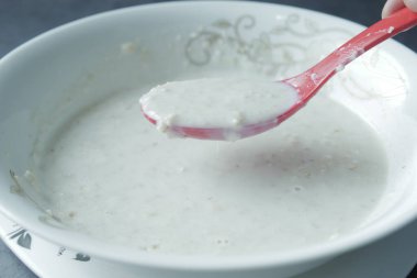 Yulaf, muz ve süt siyah arka planda bir kasede .