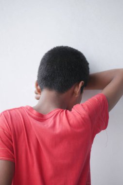 üzgün çocuk yüzünü gizliyor .