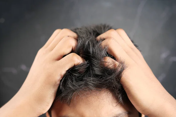 teenage boy Scratching Head Against black background